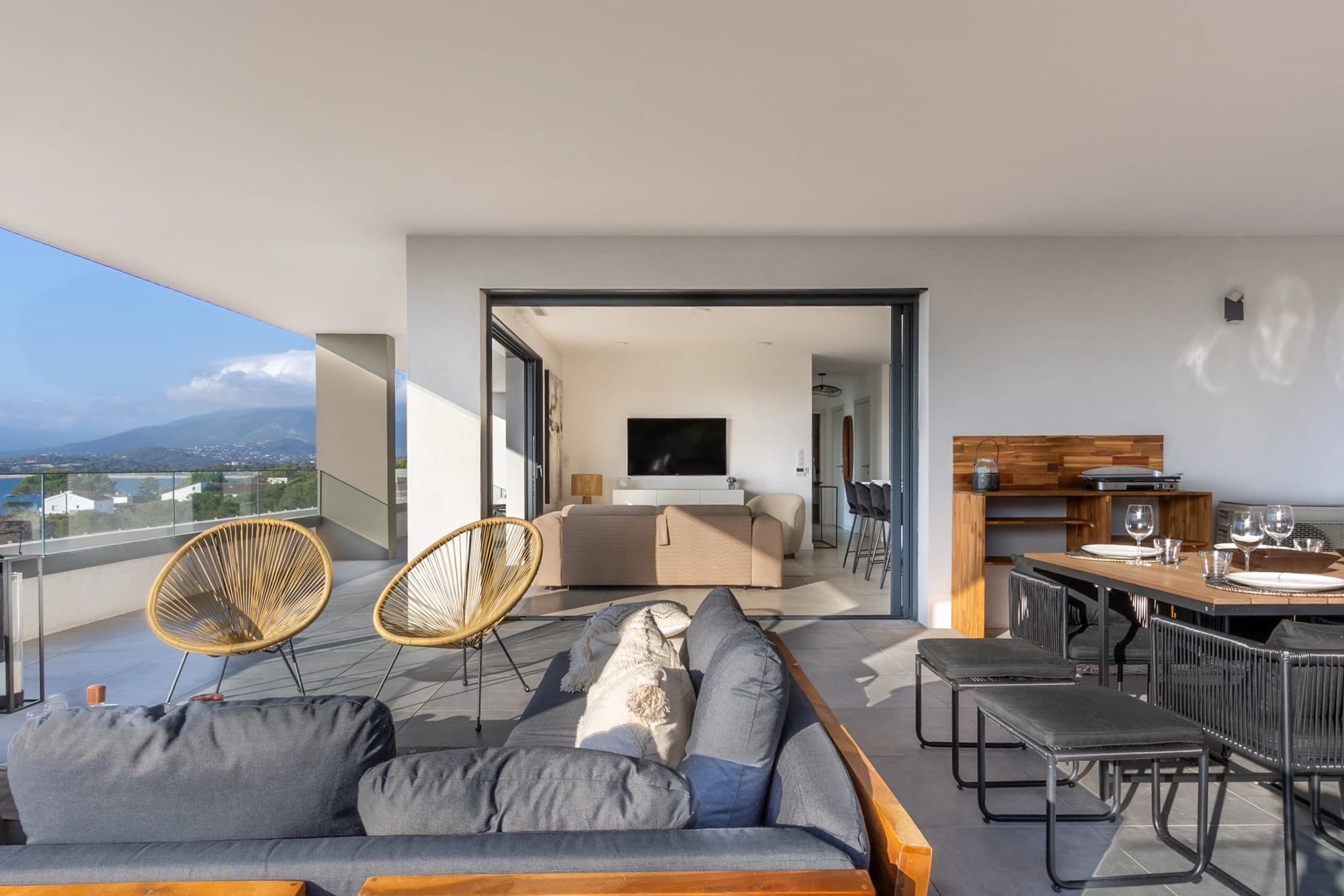 Extérieur d'une villa de luxe avec terrasse et vue sur la mer Méditerranée en Corse, photographie de prestige.